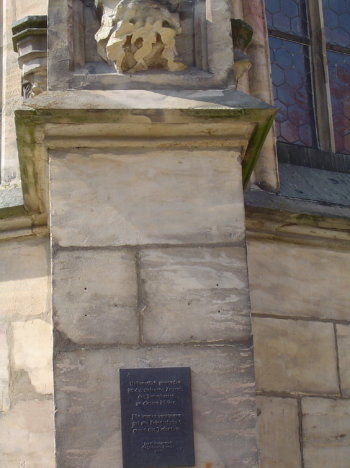 stone pillar with destroyed sculpture and commemorial plaque