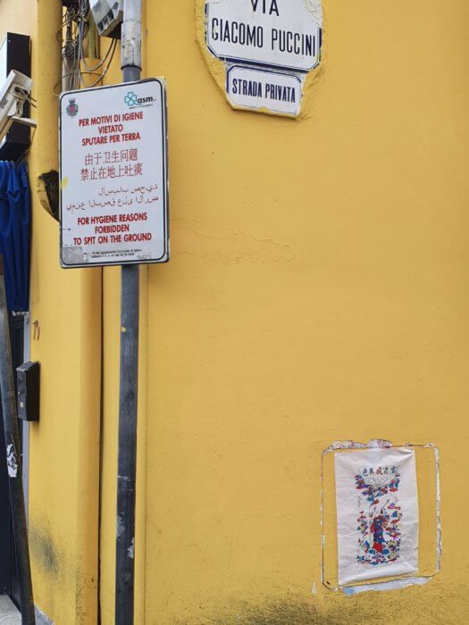 Fig. 5: Nianhua prints next to one of the many multilingual “cautionary” street signs installed by the City Council.